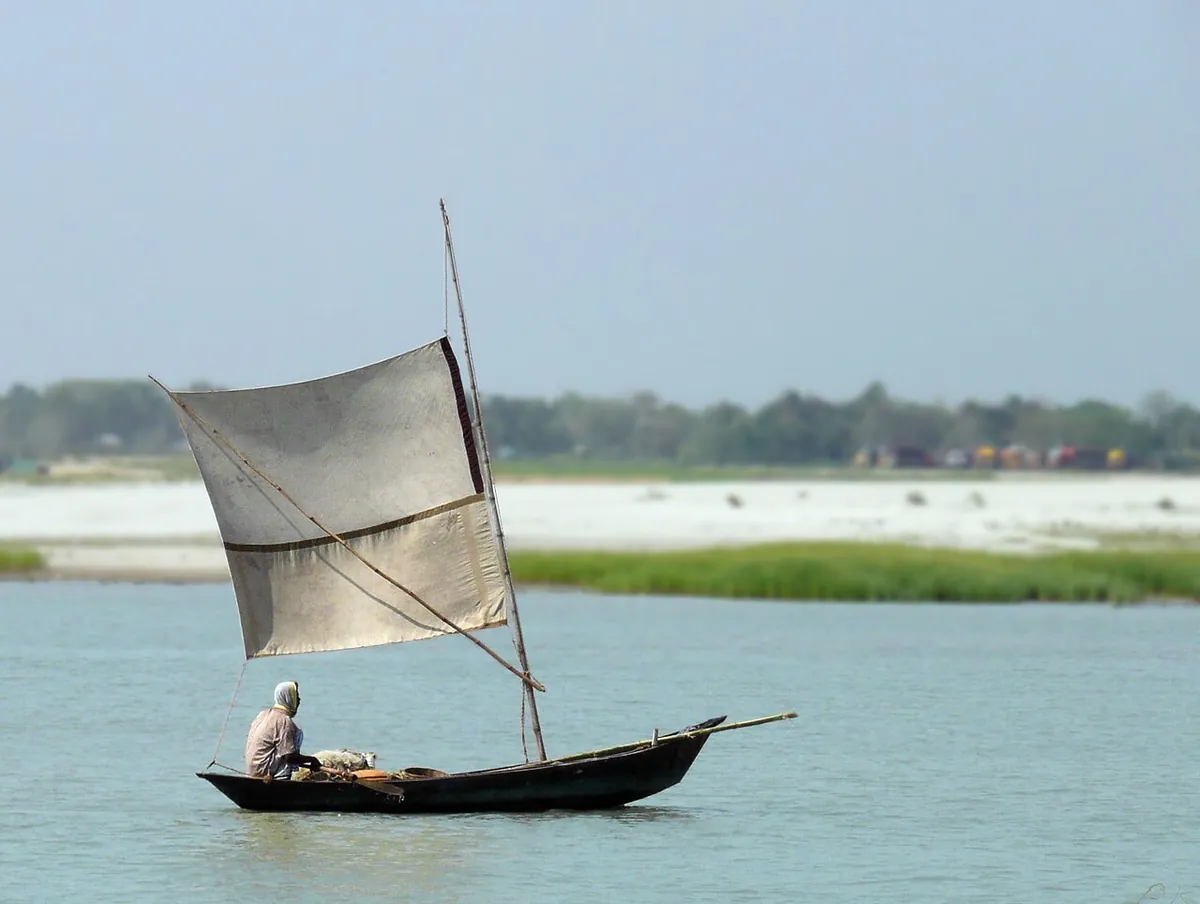 পালতোলা নৌকায় একজন মাঝি